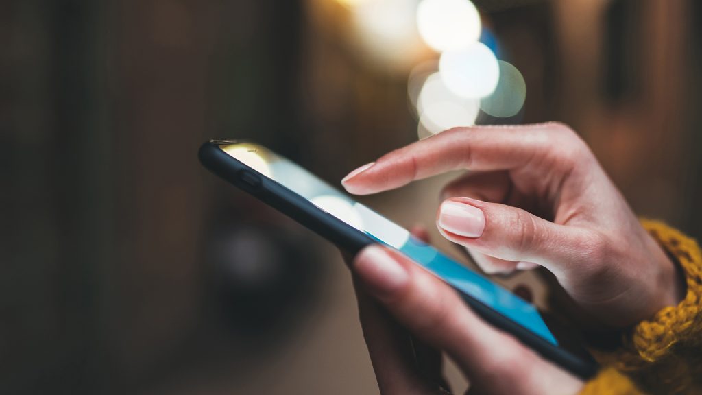 Image of a woman's hand while she texts on a cell phone
