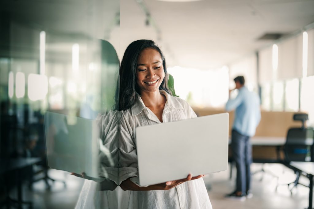 Image of an Asian-American woman holding a laptop computer.